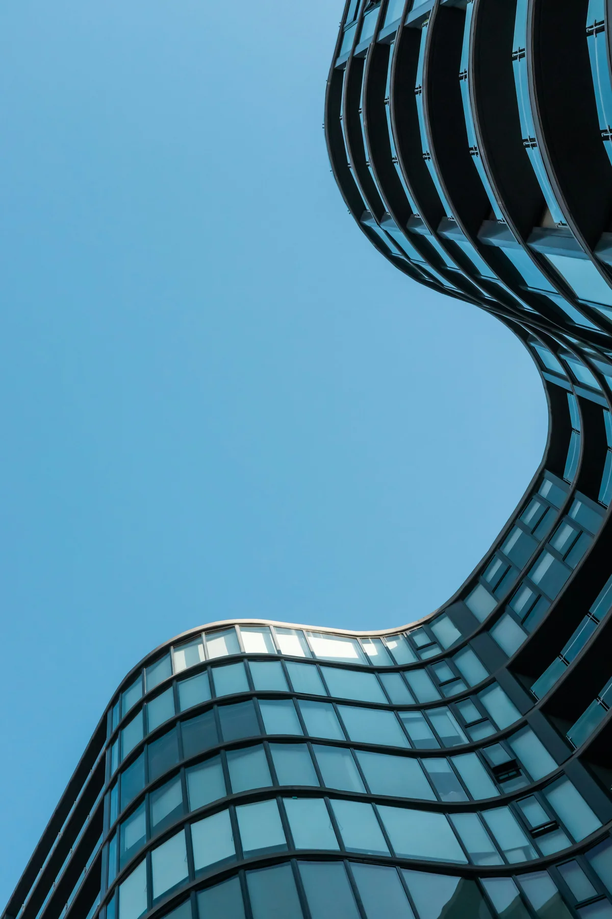 Curved glass facade framing the sky in Melbourne